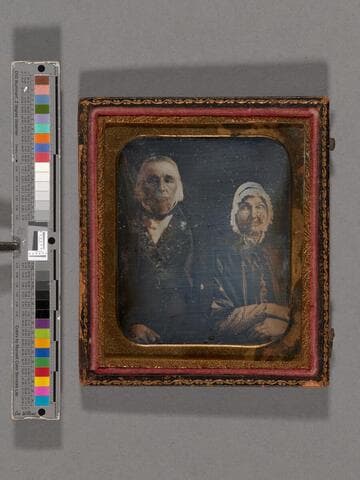 Portrait of unidentified older man and woman seated side-by-side