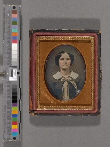 Portrait of unidentified woman wearing large white collar and striped bow