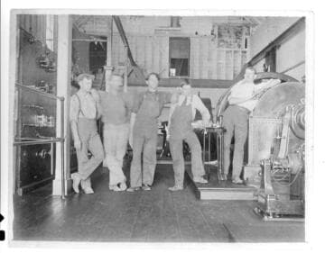 Five men standing next to the switchboard and generators in Mill Creek #1 Hydro Plant