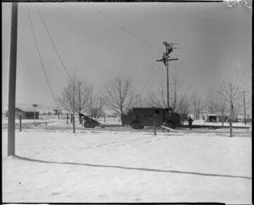 Linemen working on pole in snow at corner of Ave. K