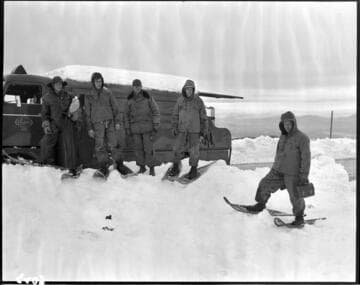 Linemen walking to distribution pole with snow shoes
