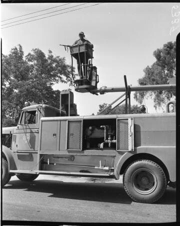 Man in bucket with boom returned to cradle in truck