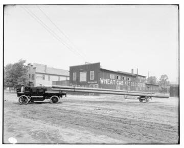Heavy electric truck #160 with load of poles on dolly