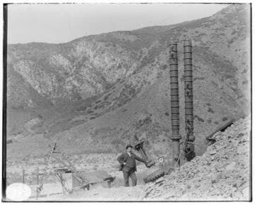 A man standing next to the air (surge) chambers at Mill Creek #3 Hydro Plant