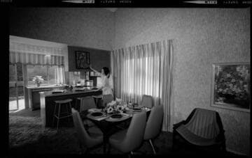 New home interiors with a homemaker using her all-electric kitchen