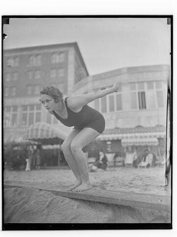 Swimmer in dive pose in front of Club Casa del Mar, Santa Monica, California
