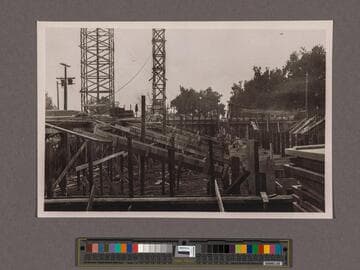Huntington Library Construction: view showing scaffold through the Center Wing from which concrete is poured into forms of outside walls of the Center Wing, looking south on west side