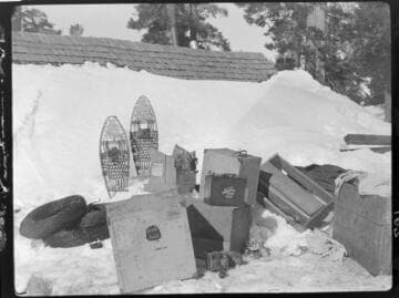 Snow gear and equipment staged outside field survey cabin in snow