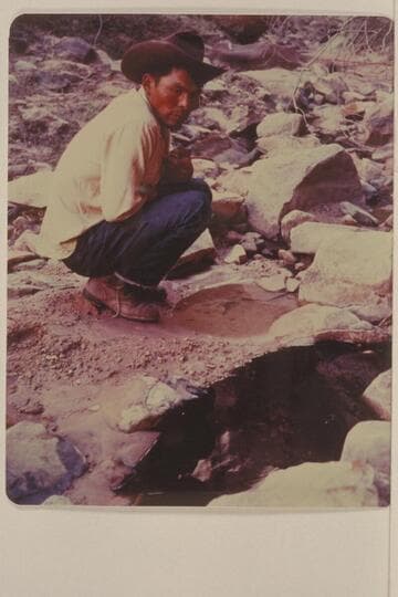 Bahe examines the clear and the black water in Black Water Creek just below Black Water Cave.  North side of Navajo Mountain
