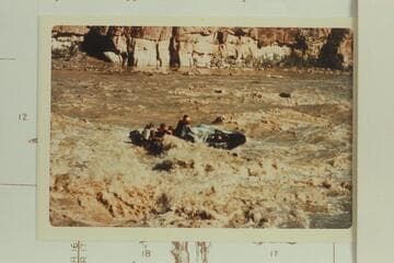 George Stewart's 10-man, with the 6 HP outboard drowned, swings down Coal Creek Rapid after clearing the hole at lower left.  The difficulty was due to being off course to the right about 10-15 ft