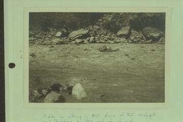 Parley Galloway riding Clyde Eddy through Hance Rapid.  Eddy is sitting in the stern of the cockpit and holding to the splash shield