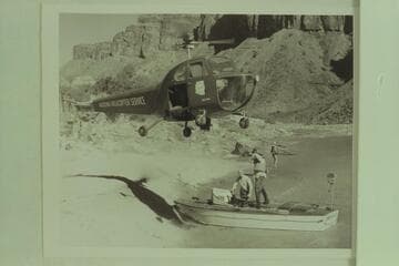 Red Carson piloting the helicopter as it hovers over the "Esmeralda" at the beach above Hance Rapid.  Left to right:  Joe Desloge and Ed Hudson.  Marston at the edge of the beach in background