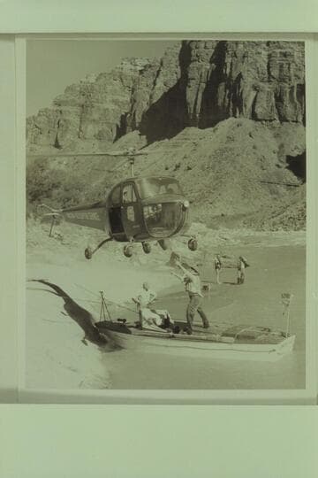 Red Carson piloting the helicopter over the "Esmeralda" at the head of Hance Rapid.  Joe Desloge and Ed Hudson are in the boat.  Marston and Taylor in the background
