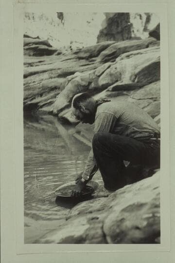 Harry Correll demonstrating gold panning at mouth of Dirty Devil