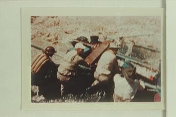 Crew dragging on the pontoon trying to free it from the nose of the rock in Bedrock Rapid.  Allan Smith; Smokey Patton; Smuss Allen; Walt Emery.  The crew are struggling to get the pontoon off the rock immediately after it hit