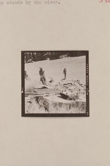 Rod Sanderson and Claude Nichols at Russell-Tadje boat, the "Ross Wheeler," left on the left bank above Bass Cable in 1915.  Belknap stands by the river