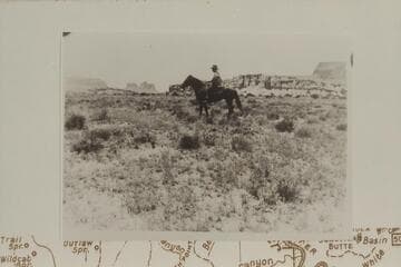 Ned Chaffin on Captain.  Water Hole Flat.  Sunset Pass and Gunsight Butte in background