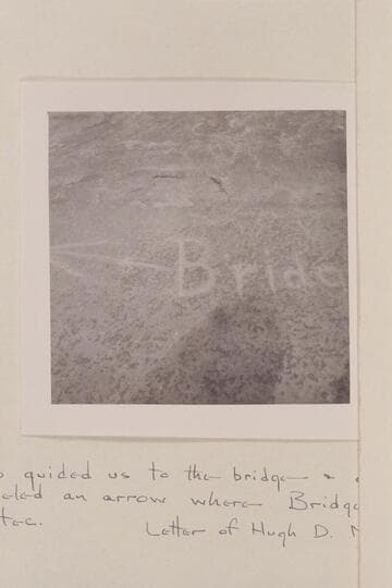 Direction sign cut in wall at mouth of Bridge Canyon