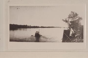 Skiff ferry carrying small buggy at Ehrenberg.  The ferry is on its side at the right bank.  Copied from print owned by Mrs. Fred V. Kuehn of Quartzite