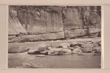 Undercut cliff at Triplet Rapid.  Low water.  Boat is the "Galloway" piloted by Lug Larsen