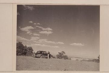 Chet Bundy stands by our car near the top of Mt. Logan.  The Grand Canyon appears in the distance
