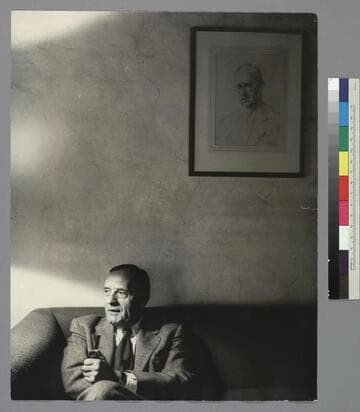 Portrait of Edwin Powell Hubble sitting below a portrait of Sir Arthur Stanley Eddington