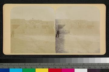 View of a man in a suit in front of adobe houses at Acoma Pueblo
