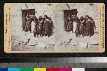 A group of Hopi children stand near a doorway