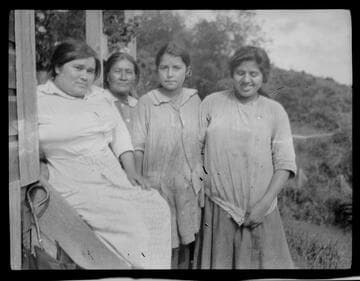 Four unidentified Native American women on steps of house