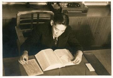 Y. C. Hong reading a book at his desk