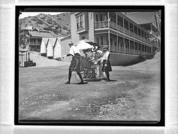 Group of people with baby carriage in the street, Catalina Island