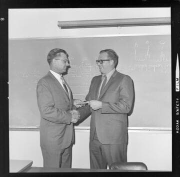 Men reviewing certificates of completion for Edison electronics training