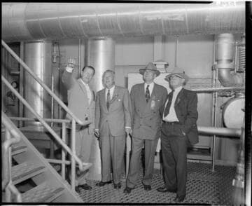 Four men touring the interior of Etiwanda Generating Station