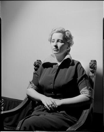 Lady seated in chair against white backdrop
