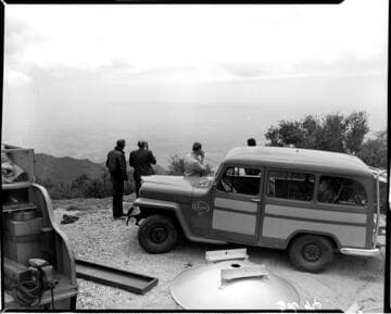 Line crew staging anntenna parts by field vehicles