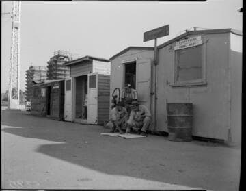 Workers going over plans by carpenters shed