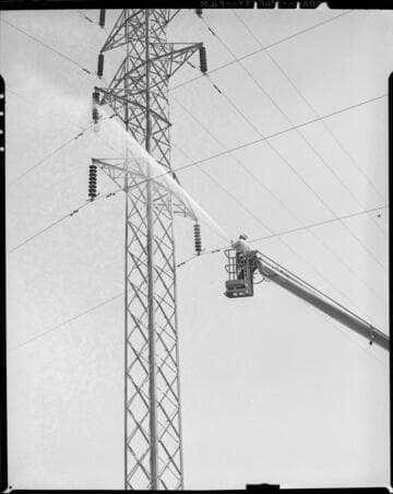 Washing insulators on double circuit  tower with high pressure water gun from raised bucket