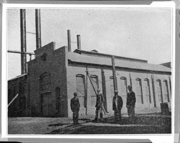 Four men standing outside San Bernardino Steam Plant
