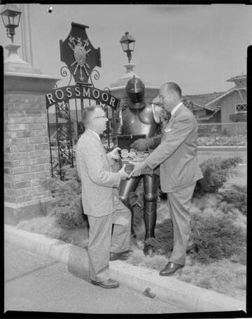 Knight in armor with a chest of Medallion Home discs for Rossmoor tract developers