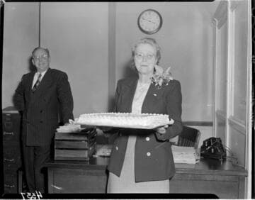 Lady with corsage holding cake