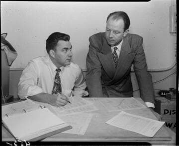 Two men reviewing chart data