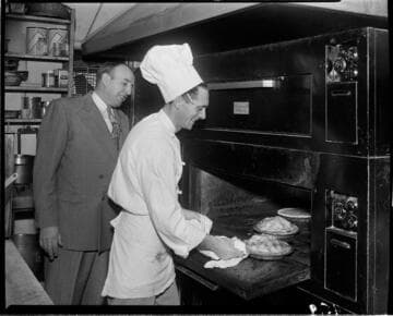 Chef taking pies out  of oven