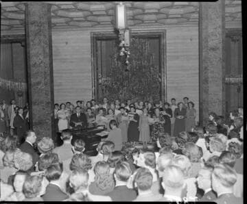Edison chorus performing by Christmas tree in Edison General Office lobby