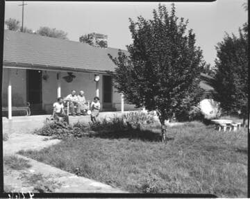 Family sitting on back porch of their home
