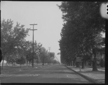 Linemen on a divided road removing wooden transmission poles on road division