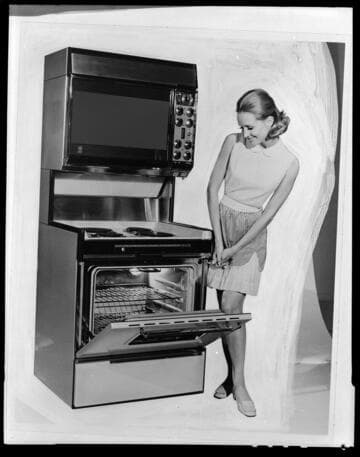 Promotional photo of woman posed next to an electric range
