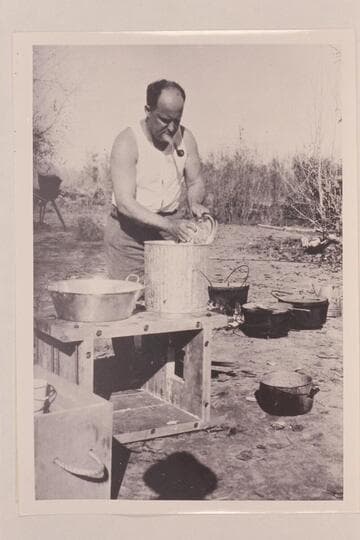 Val Woodbury washing dishes at Greenriver, Utah.  Pathe-Bray party