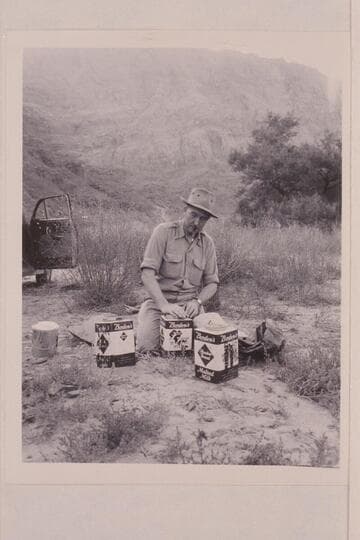 Bestor Robinson stowing food in slip-cover cans.  Lees Ferry