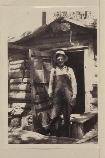 Bert Loper at door of his cabin.  Red Canyon in Glen Canyon